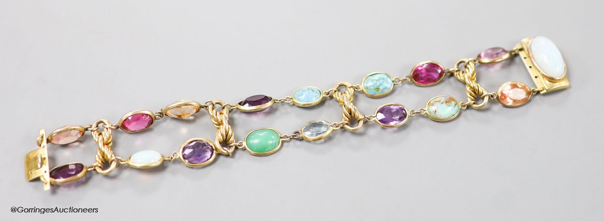 An early 20th century yellow metal and multi gem set bracelet, including white opal, turquoise, amethyst etc, 17cm, gross weight 30.3 grams.